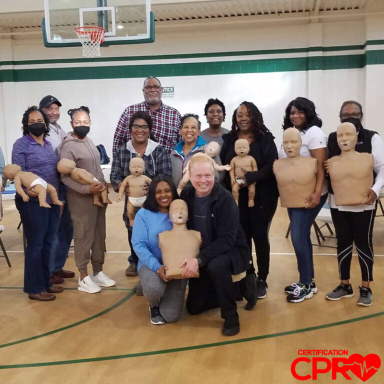 Group of Teachers and Students Holding CPR Training Mannequins on a School Basketball Court