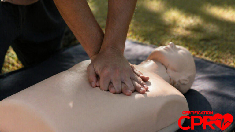 Person performing hands-only CPR on a mannequin outdoors in Orlando.